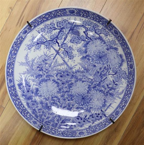 A large Chinese porcelain wall plate, painted with birds and flowering shrubs in underglaze blue